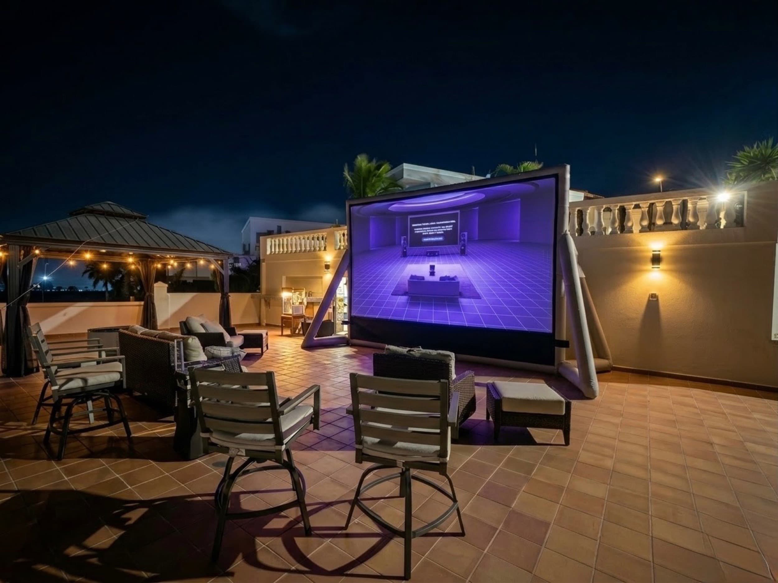 The 200-inch screen glowing on the Casa Nakhla terrace at night